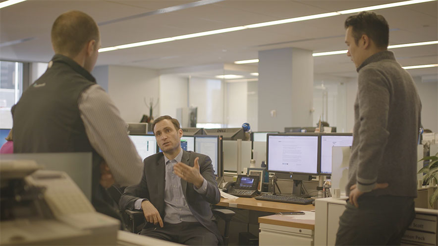3 people having a conversation in the office