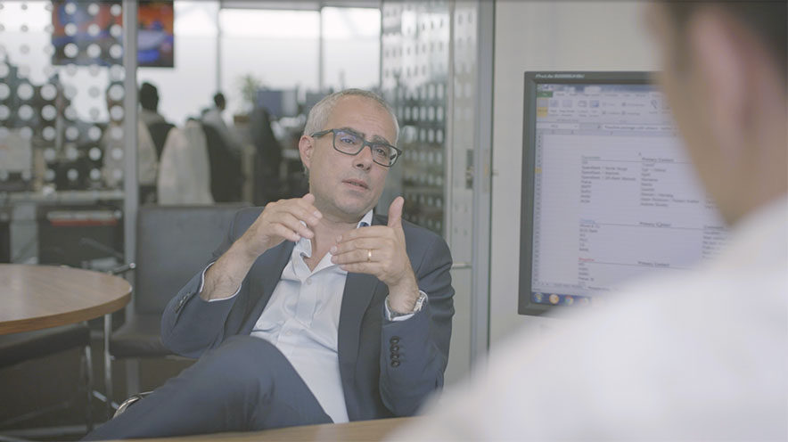 Man sitting at desk talking to someone